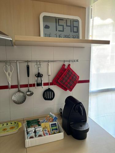 a kitchen counter with a clock on the wall at Appartamento zona Rho Fiera in Arese
