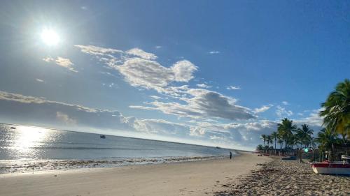 a sandy beach with palm trees and the ocean at Casa Beira Mar in Santa Cruz Cabrália