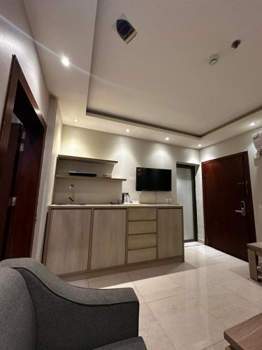 a living room with a couch and a flat screen tv at لؤلؤة الشرق للشقق المخدومة Luluat Al sharq For Serviced Apartment in Hafr Al Baten