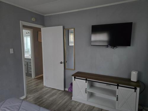 a room with a bed and a tv on a wall at Cozy Haven in Hampton Roads Near Beaches, Military Bases & Historic Sites in Hampton