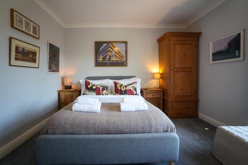 a bedroom with a large bed with two pillows at Vibrant 2 Bed, 2 Bath Home, Just Minutes to Town! in Ross on Wye