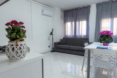 a kitchen and living room with a vase with flowers in it at Appartamenti DueC in Trapani