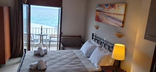 a bedroom with a bed with a view of the ocean at DIOLKOS APARTEMENT in Nea Roda