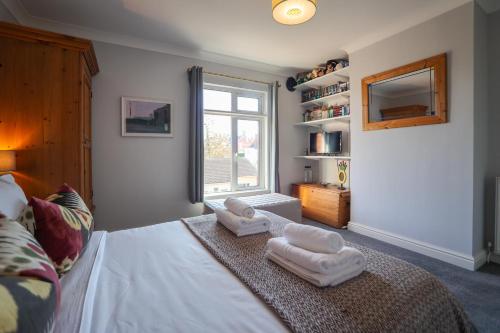 a bedroom with a bed with towels on it at Vibrant 2 Bed, 2 Bath Home, Just Minutes to Town! in Ross on Wye