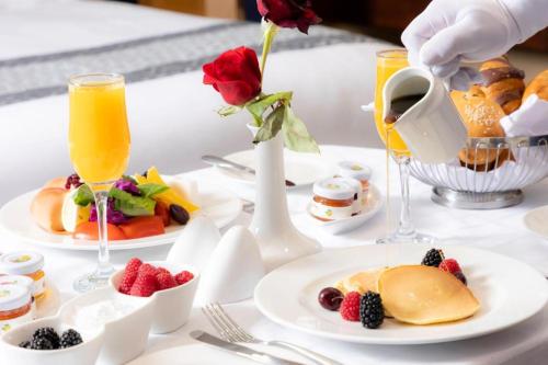 a table with plates of food and glasses of orange juice at Nozol Royal Inn Hotel in Al Madinah
