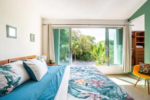 a bedroom with a bed and a large window at Lux 4BR Playacar Villa with Pool in Playa del Carmen