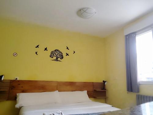 a bedroom with a bed with birds on the wall at Txoko Maitea Pentsioa in Urnieta