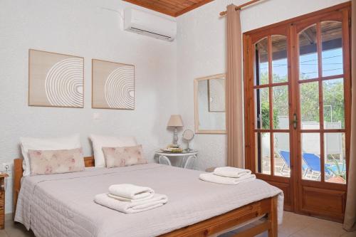 una camera da letto con un letto con lenzuola bianche e una finestra di Batilas House next to exotic beach of Elafonisi a Elafonisi