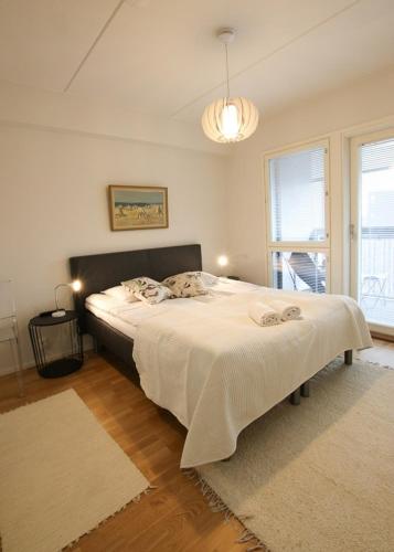 a bedroom with a large bed with a white blanket at Uniikki kolmio Aurajokinäkymin in Turku