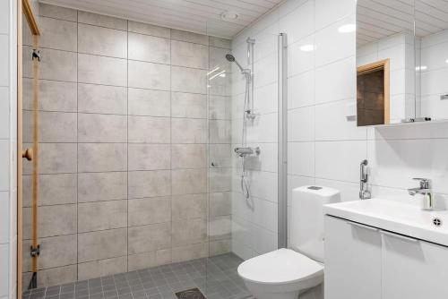 une salle de bain avec une douche, des toilettes et un lavabo dans l'établissement Uniikki kolmio Aurajokinäkymin, à Turku