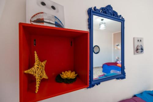 a red cabinet with a mirror in a bedroom at Casa vacanza da Giuseppe in Leonforte