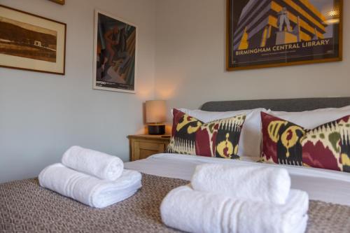 a bedroom with a bed with white towels on it at Vibrant 2 Bed, 2 Bath Home, Just Minutes to Town! in Ross on Wye