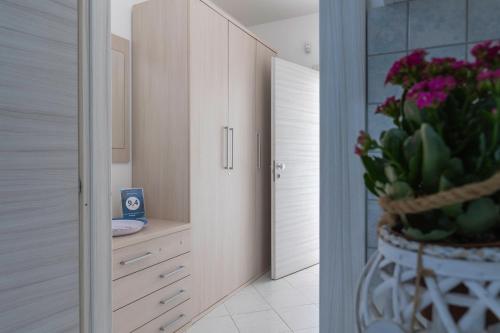 a bathroom with a sink and a vase of flowers at Appartamenti DueC in Trapani