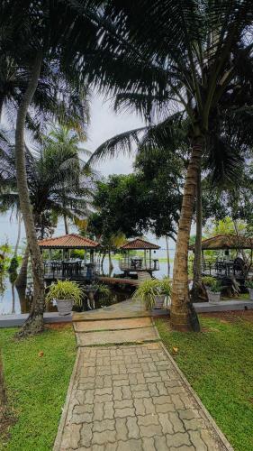 a walkway with palm trees in a resort at Hotel Milenium in Kurundankulama