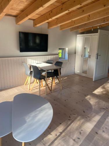 a dining room with a table and chairs and a tv at foresthaus in Glücksburg