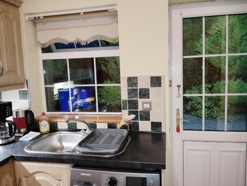 a kitchen with a sink and a window at Welcome to Tunmobi Villa, its home away from home. in Ballyjamesduff