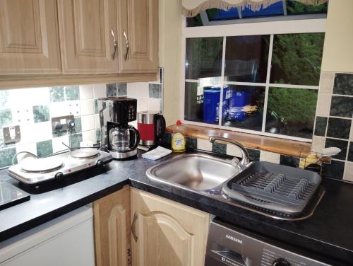 a kitchen counter with a sink and a window at Welcome to Tunmobi Villa, its home away from home. in Ballyjamesduff