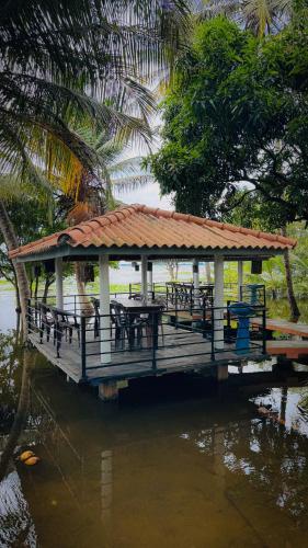 a pavilion with tables and chairs on the water at Hotel Milenium in Kurundankulama