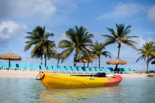 a yellow boat sitting on the water next to a beach at Catalonia Montego Bay - All Inclusive in Montego Bay