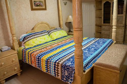 a bedroom with a bed with a wooden frame at ZenBreak Marzalea Villa 3bd in Saint James