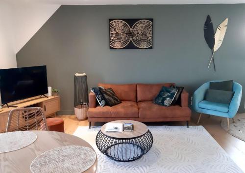 un salon avec un canapé et une table dans l'établissement VUE MER panoramique sur la baie de St-Cast-le-Guildo, à Saint-Cast-le-Guildo