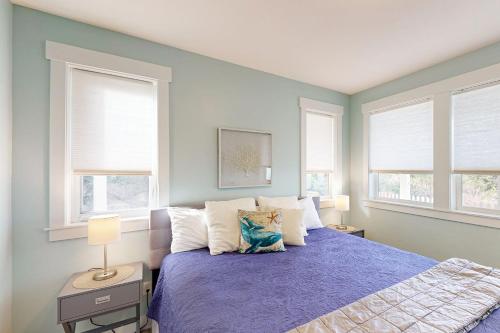 Un dormitorio con una cama con paredes y ventanas azules. en Blue Bayou, en Lincoln City
