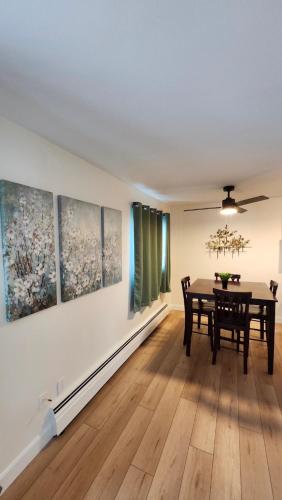 a dining room with a table and some paintings on the wall at ENTIRE 2 BEDROOM APARTMENT by UW RESEARCH PARK - PS5 in Waterloo