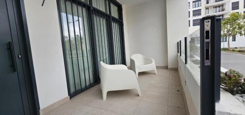 a balcony with two white chairs and large windows at Vacansis Masamagrell Bajo Loft Tomas y Valiente in Masamagrell