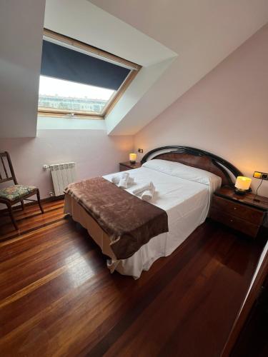 a bedroom with a large bed and a window at Gestiona2R- Casa grande para 12 en Llanes 6 dormitorios Jardín y espacio exterior in Llanes