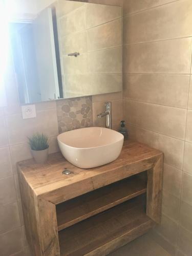 La salle de bains est pourvue d'un lavabo blanc sur un comptoir en bois. dans l'établissement Beach house Océan Ile de Ré, au Bois-Plage-en-Ré