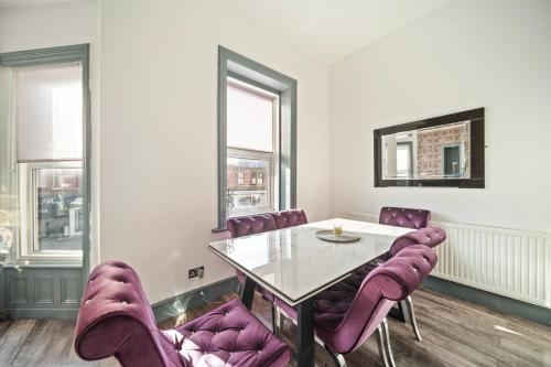 a dining room with purple chairs and a table at Spacious, Central Townhouse with Hot Tub & Free Parking in Lytham St Annes