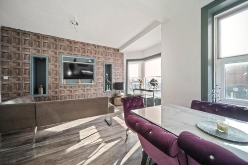 a living room with a tv on a brick wall at Spacious, Central Townhouse with Hot Tub & Free Parking in Lytham St Annes