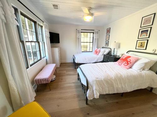 a bedroom with two beds and a tv and windows at 2109 Landfall Way in Seabrook Island
