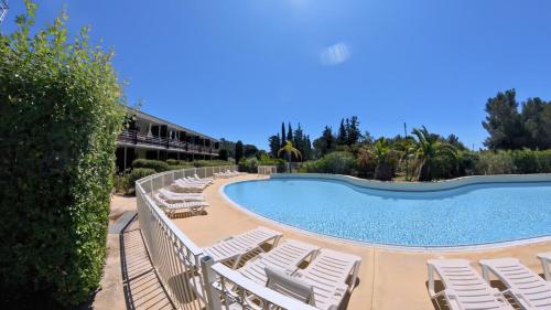 une rangée de chaises longues à côté d'une piscine dans l'établissement T2 6 couchages, piscine et mer, à La Ciotat