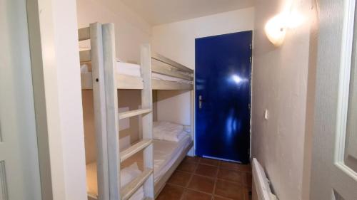 Cette chambre comprend 2 lits superposés et une porte bleue. dans l'établissement T2 6 couchages, piscine et mer, à La Ciotat