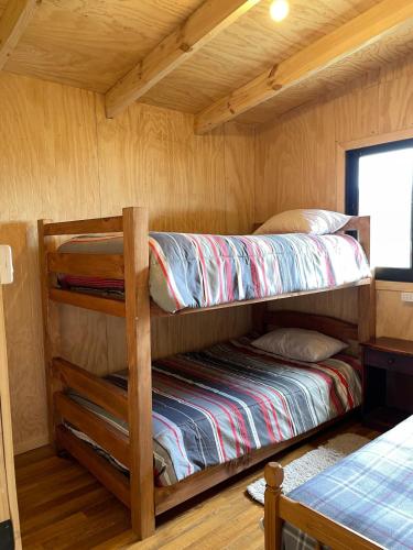 a bedroom with two bunk beds in a cabin at Cabaña el tilo in Lago Ranco
