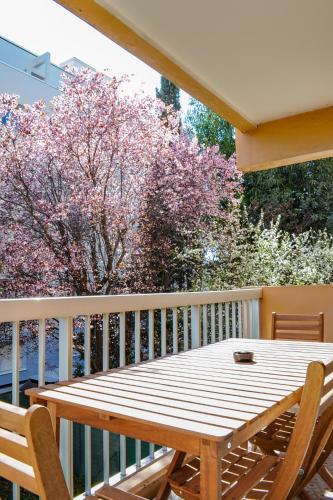 une table en bois et deux chaises sur un balcon dans l'établissement Appartement Cosy, Calme et Climatisé proche centre, à Antibes