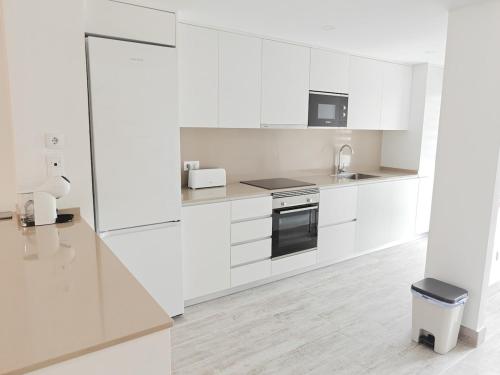 a white kitchen with white cabinets and a sink at The Garden House in Alicante