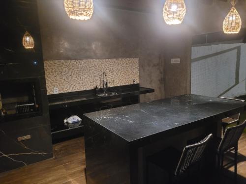 a kitchen with a black counter and a sink at Castelo Boulevard in Tibau do Sul