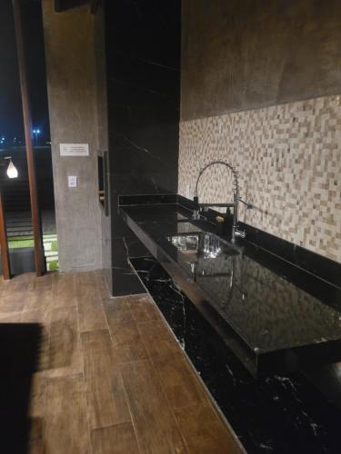 a bathroom with a black counter and a sink at Castelo Boulevard in Tibau do Sul