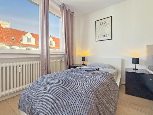 a bedroom with a bed and a large window at Heart of Hannover Apartment in Hannover
