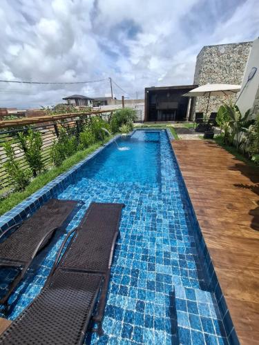 a large swimming pool with blue tiles in a yard at Castelo Boulevard in Tibau do Sul