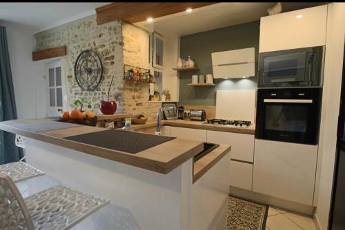 une cuisine avec un grand îlot au milieu dans l'établissement Maison de ville avec terrasse, à Bayeux