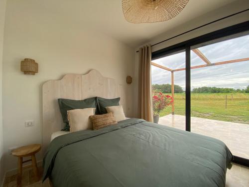 une chambre avec un lit et une grande fenêtre dans l'établissement Tiny house avec spa en Dordogne, à Saint-Seurin-de-Prats