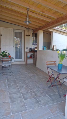 un patio avec une table et des chaises et une cuisine dans l'établissement Le jardin des oliviers, à Apt