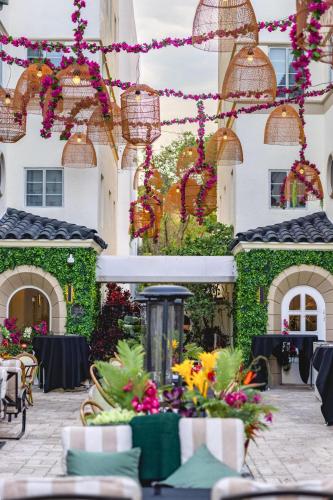 a courtyard with tables and flowers in front of a building at Hotel Ocean in Miami Beach