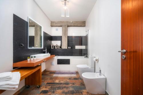 a bathroom with a sink and a toilet and a tub at Oakmoon House in Faro