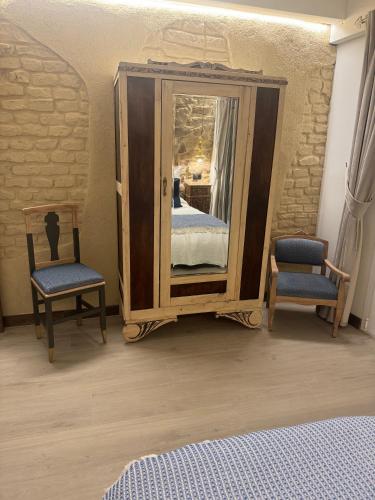 a bedroom with a mirror with a bed and two chairs at Casa Rural Garabitero in Laguardia