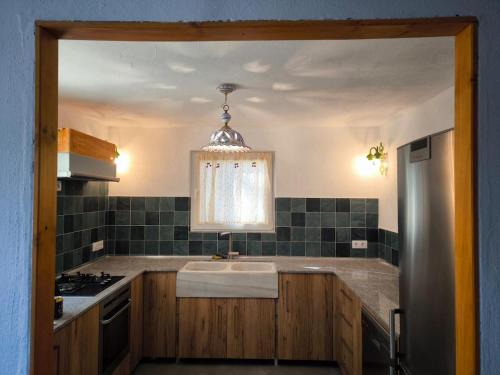 a kitchen with a sink and a stove at Beautiful mountain chalet in Siete Aguas