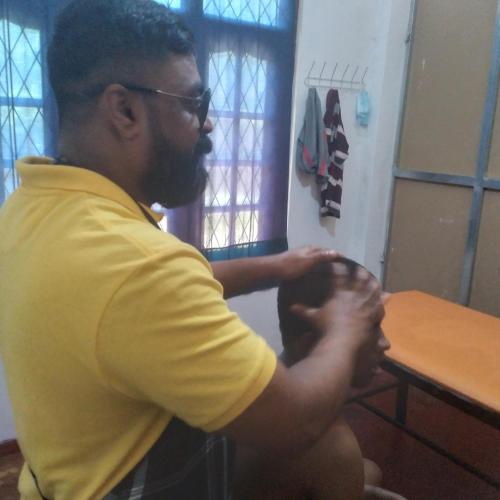 a man sitting at a table holding his hands at Jayathmaguest in Peradeniya